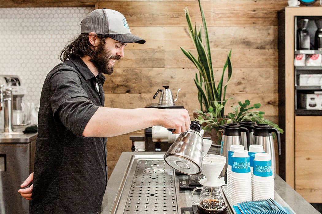Garrett Henry works the pour-over station at Blueprint Coffee. | Photo by Jennifer Silverberg.